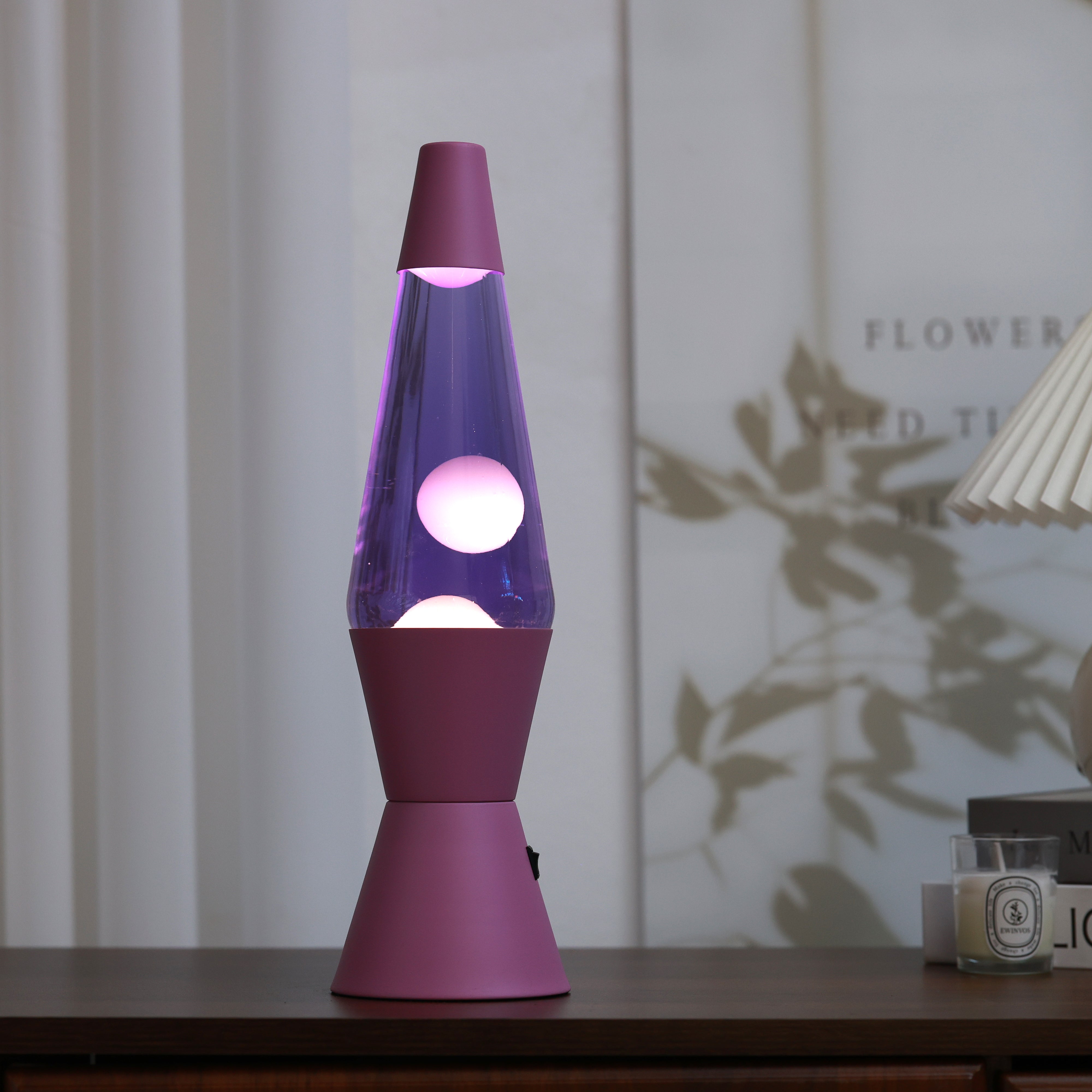 Violett leuchtende iTotal LED Lavalampe Spaceship als dekoratives Element auf einem Holzmöbel in modernem Interieur.