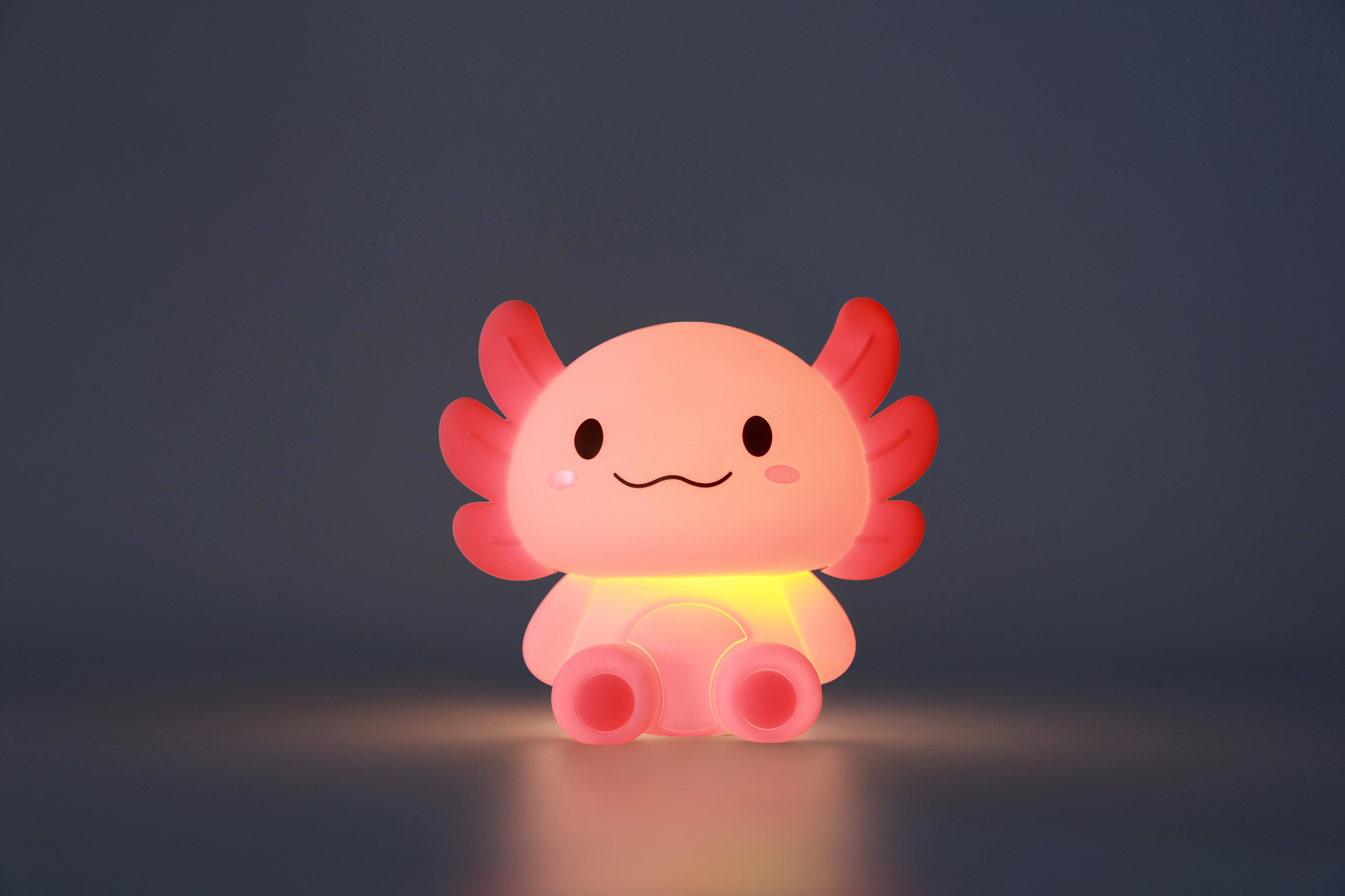 Sanft leuchtendes iTotal Axolotl-Nachtlicht aus Silikon in stimmungsvoller Umgebung.