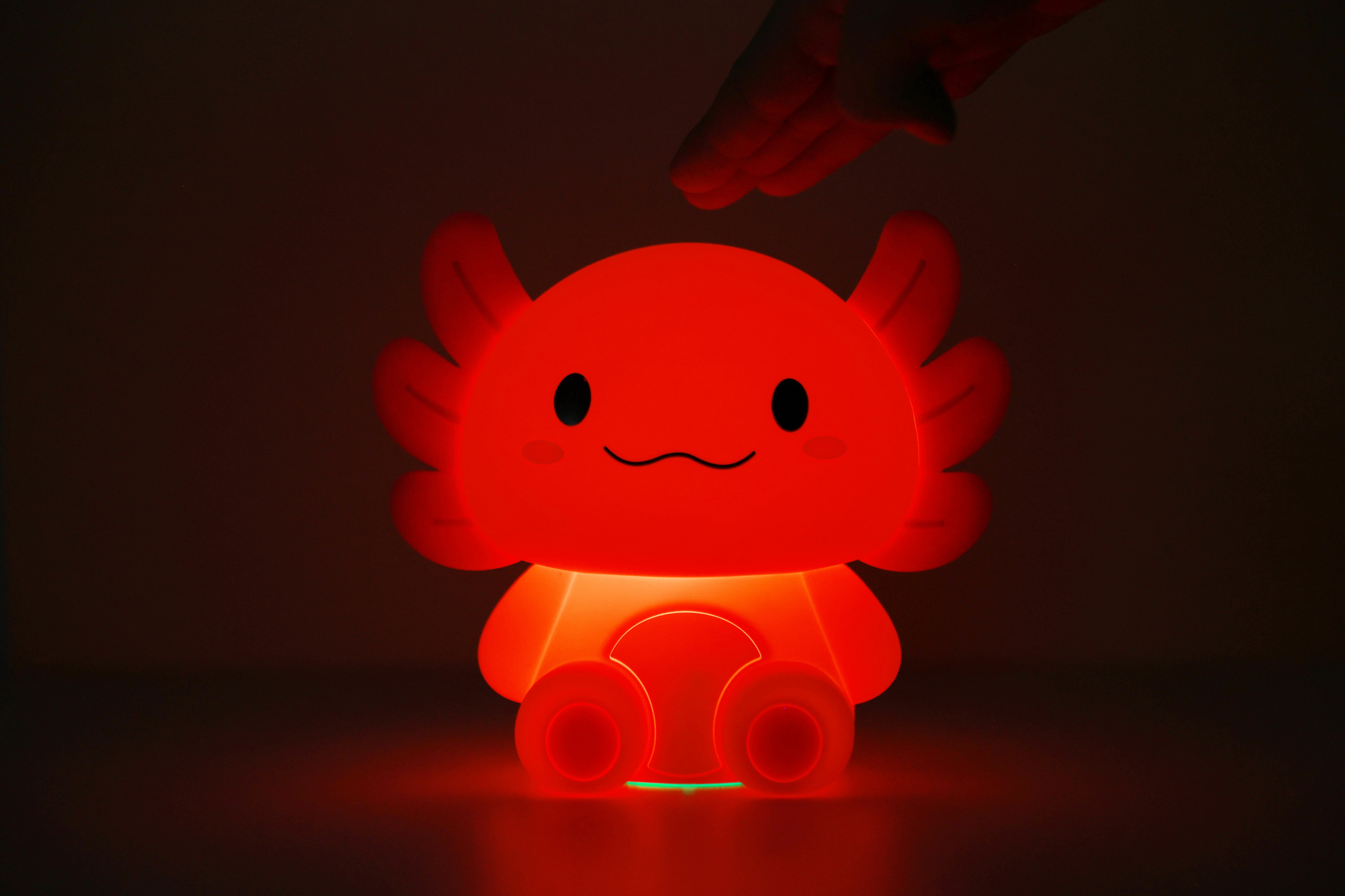 Rot leuchtendes iTotal Axolotl-Nachtlicht aus Silikon in dunkler Umgebung.