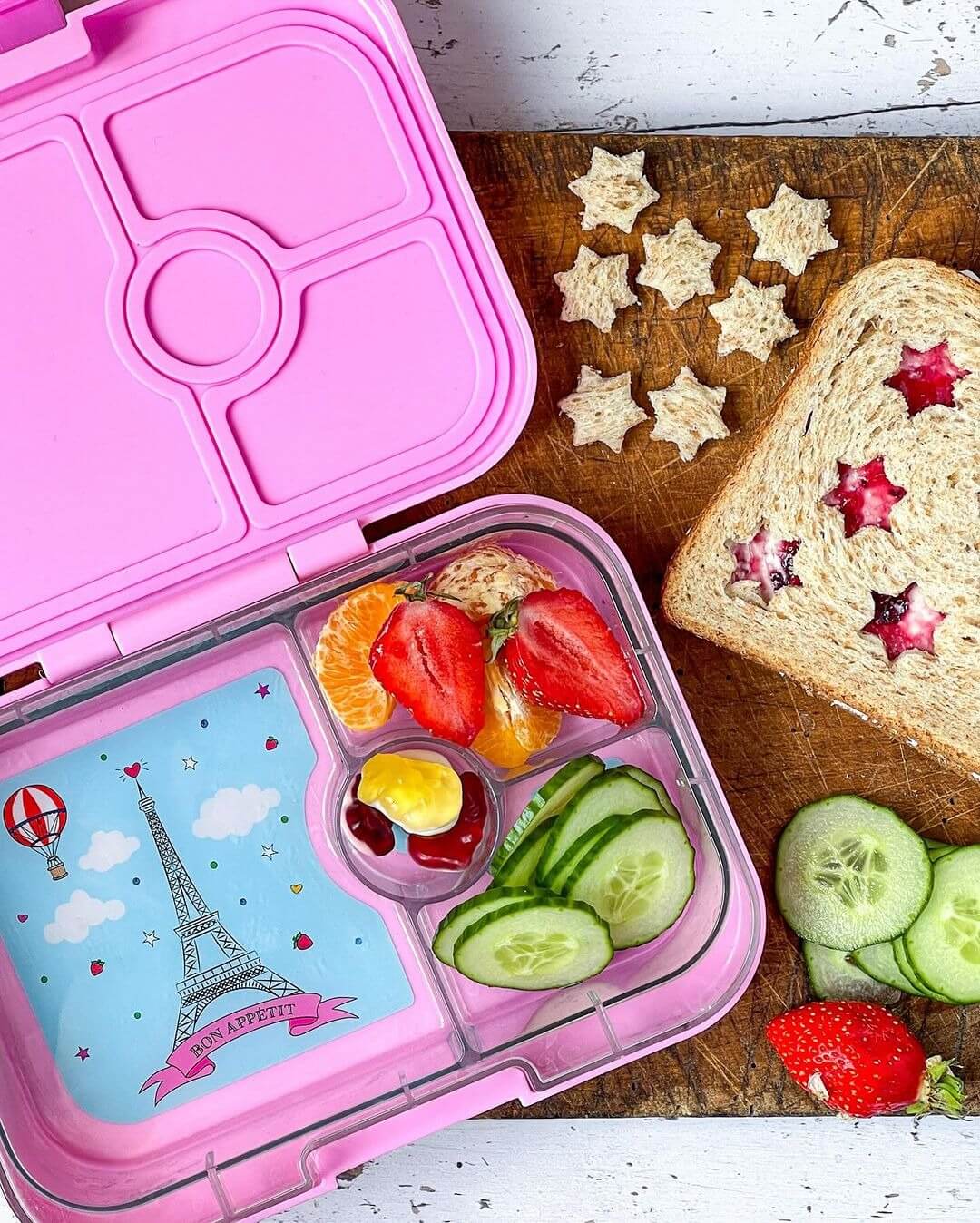 Yumbox Panino Lunchbox, Fifi Pink, offen, befüllt mit Erdbeeren, Mandarinen, Gurken, Dip, Bento-Box, Paris-Motiv, gesund, Trennung, Schule, Picknick, vielseitig.