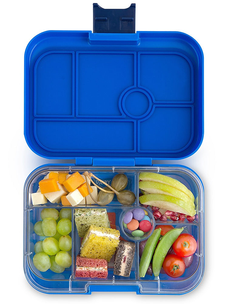 Yumbox Original Surf Blue, geöffnete Lunchbox, Bento Box, blau, Unterteilungen, Käsewürfel, Weintrauben, Mini-Sandwiches, Apfelscheiben, Tomaten, Zuckerschoten, Smarties, gesund, Kinder.